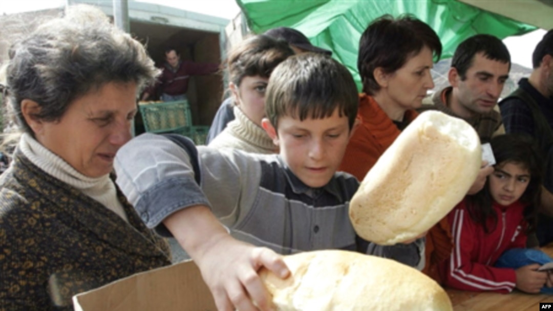 Refugees receiving bread at a camp for displaced persons outside Gori