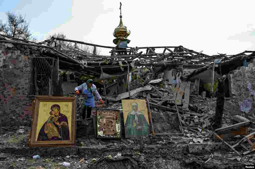 Ez maradt húsvétra a Zaporizzsjai területen fekvő Komisuvakha falu templomából egy rakétacsapás után. A képen egy nő próbálja meg összegyűjteni az épen maradt ikonokat a romok közül április 16-án
