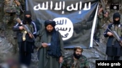 IMU leader Usmon Ghazi (second left) and his fighters are shown taking an oath of allegiance, in Arabic, to IS and its leader Abu Bakr al-Baghdadi.