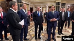 Reprezentanți ai delegațiilor SUA și Federației Ruse discută pe hol înainte de începerea negocierilor inclusiv despre încetarea războiului din Ucraina, la Riad, Arabia Saudită, 18 februarie 2025.