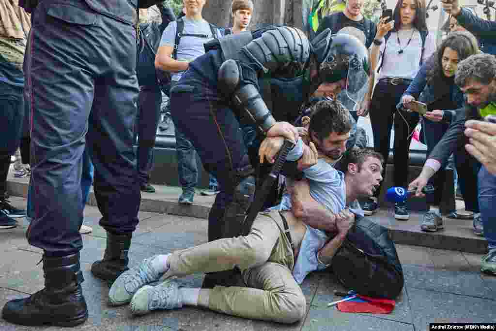 &quot;Настоящее времянын&quot; алып баруучусу Тимур Олевский Москвадагы митингге чыккан кишини полиция кармап жаткан учурда андан интервью алганга аракет кылууда. 3-август.