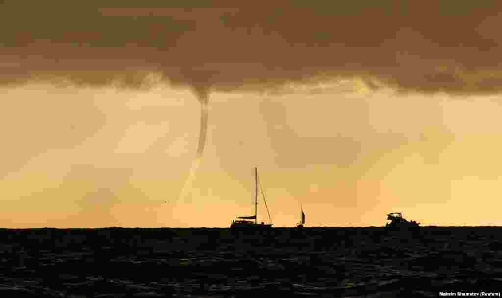 Boats sail in the Black Sea near a tornado at sunset in Sochi, Russia, on September 28.