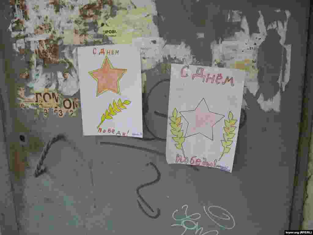 В &nbsp;Севастополе школьники расклеивают нарисованные ими открытки к 9 мая. В этом году &nbsp;они &quot;штамповали&quot; рисунки по заранее заготовленным шаблонам с атрибутами советского периода. Ул. Ерошенко, Севастополь