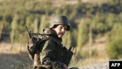 A Turkish soldier sits on a road in the province of Sirnak, near the Turkish-Iraqi border