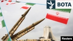 Flamujt iranianë valëviten pranë raketave të ekspozuara, ndërsa Kulla Azadi shihet në sfond, gjatë 47-vjetorit të Revolucionit Islamik në Teheran, më 11 shkurt.