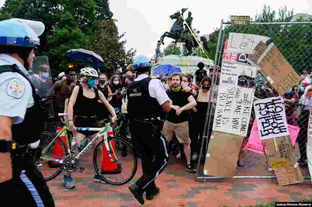 Поліцейські, які охороняють парк Лафаєт, зіштовхнулися з демонстрантами, що захищають інших учасників протесту, які намагаються знести пам&rsquo;ятник президентові США Ендрю Джексонові. Вашингтон, округ Колумбія, США