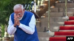 Liderul Partidului Bharatiya Janata (BJP) din India, Narendra Modi, face un gest spre adunare înainte de a depune jurământul pentru al treilea mandat ca prim-ministru al țării în timpul ceremoniei de depunere a jurământului de la palatul prezidențial Rashtrapati Bhavan.
