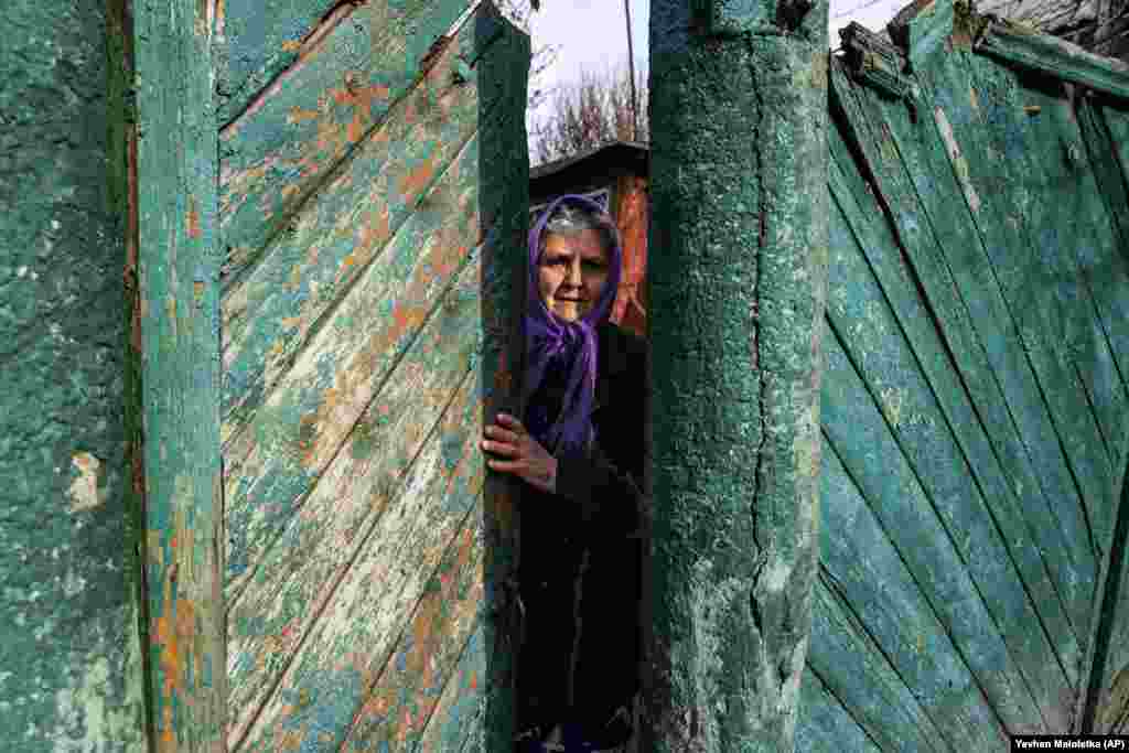 A woman stands at the gate to her house in Katerynyvka in Ukraine&#39;s eastern Luhansk region on November 1. (AP/Evgeniy Maloletka)