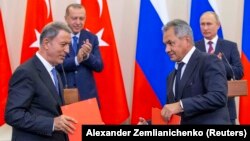 Russian President Vladimir Putin (right rear), Turkish President Recep Tayyip Erdogan (left rear), Russian Defense Minister Sergei Shoigu (right) and Turkish Defense Minister Hulusi Akar attend a news conference following the talks in Sochi on September 17.