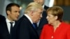 U.S. President Donald Trump (center) walks past French President Emmanuel Macron (left) and German Chancellor Angela Merkel (right) while getting into position for a group photo during a NATO summit in Brussels last May. 