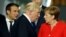 U.S. President Donald Trump (center) walks past French President Emmanuel Macron (left) and German Chancellor Angela Merkel (right) while getting into position for a group photo during a NATO summit in Brussels last May. 