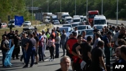 Miners and workers stand at a roadblock on the Struma Highway near Dupnitsa as they protest against government plans to close the coal industry on September 29.