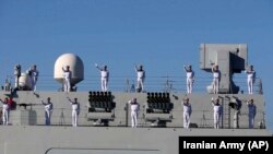 Kínai haditengerészek integetnek, miközben az iráni partokhoz érnek az Ománi-öbölben az első közös iráni–kínai–orosz hadgyakorlaton 2019. december 27-én