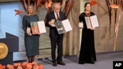 Natalia Pinchuk, the wife of Nobel Peace Prize winner Ales Byalyatski; Yan Rachinsky, chairman of the International Memorial Board; and Oleksandra Matviychuk, head of Ukraine's Center for Civil Liberties, pose with their awards in Oslo on December 1o.