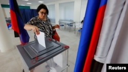 A voter casts her ballot at a polling station during elections for Russian-installed legislatures in Donetsk, Russian-controlled Ukraine, on September 8. Ukraine's Foreign Ministry called the elections a "sham." 