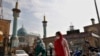 IRAN -- Iranian women wearing face masks walk past next to the Saleh shrine in Tehran, October 26, 2020