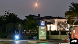 Колоездач наблюдава падаща иранска ракета в Дубай, 28 февруари 2026 г. 