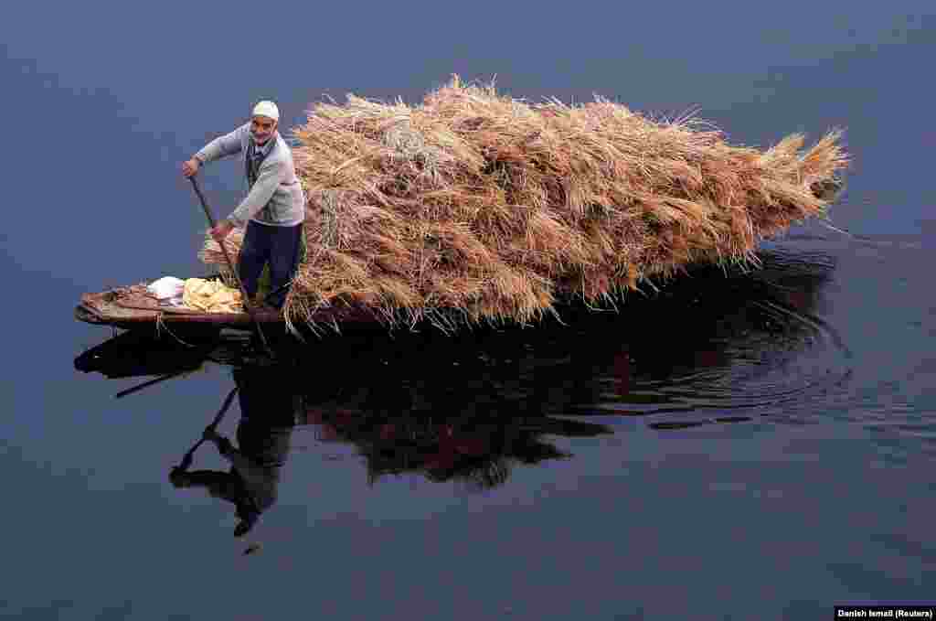 A man rows a boat filled with straw on the waters of Nageen Lake on a cold morning in Srinagar, India. (Reuters/Danish Ismail)