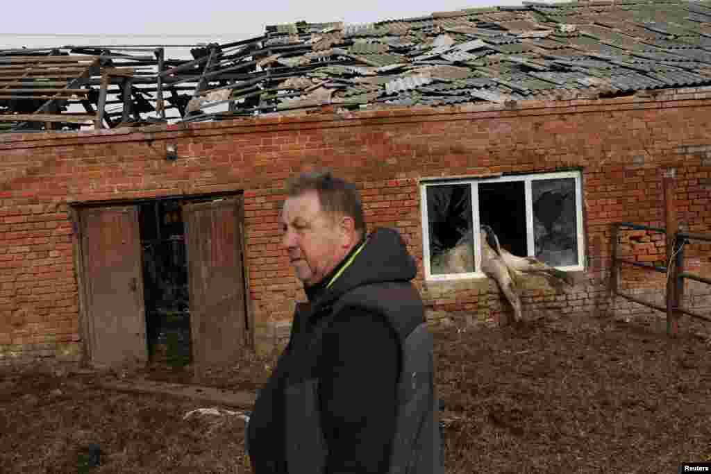 Farmer Oleksandr Novikov, 58, surveys the damage to his farm in Vilhivka, near Kharkiv, on May 11. Russian forces have been accused of looting grains and selling them to other countries, destroying fields, and killing livestock in an intentional effort to harm Ukrainian farmers during their invasion of Ukraine.