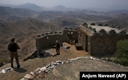 Pakistani troops observe the area from hilltop post on the Afghan border in the Khyber district.