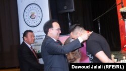 داوود جلالی مسوول انجمن ورزشکاران افغان در آنتار هنگام تفویض مدال به مصطفی یکی از اعضای تیم ملی بوکسنگ افغانستان