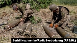 უკრაინელი ჯარისკაცები ჰაუბიცა M777-ის ჭურვებს გასასროლად ამზადებენ
