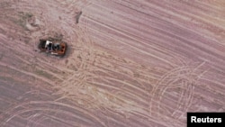 Një makinë ushtarake shihet në një tokë bujqësore, që më herët ishte minuar. Rajoni i Çernihivit, 24 maj 2022.