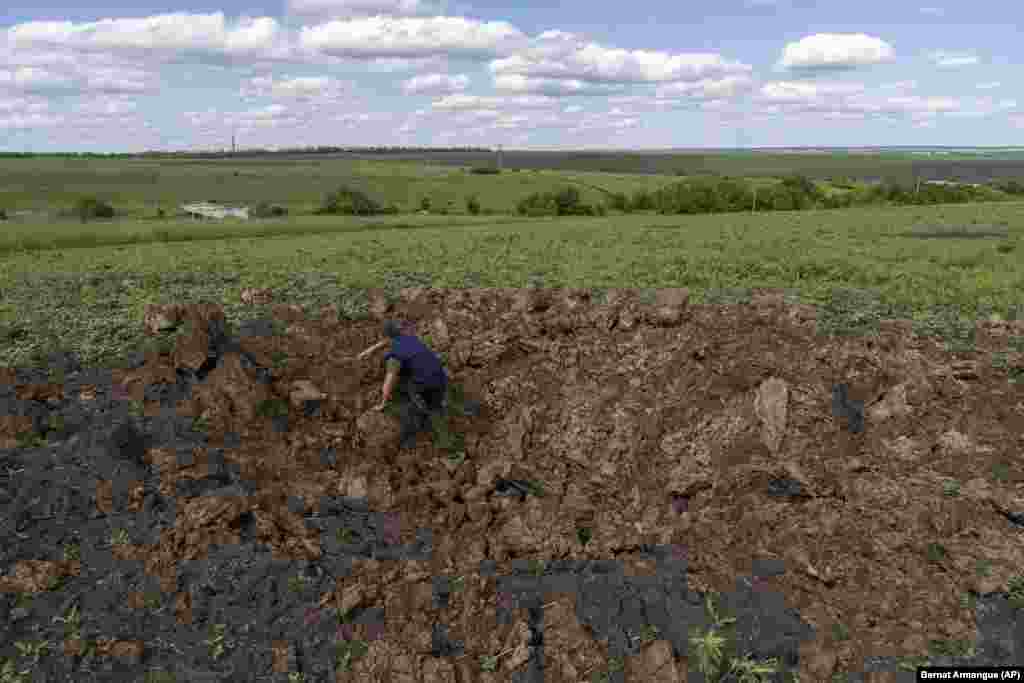 A farm worker climbs out of a crater caused by shelling in Cherkaska Lozova. The European Parliamentary Research Service reports that Russia and Ukraine supply more than half of cereal imports in northern Africa and the Middle East, while countries in eastern Africa import 72 percent of their cereals from Russia and 18 percent from Ukraine.&nbsp;