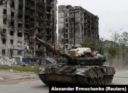 Un tanc al separatiștilor sprijiniți de Rusia se deplasează prin străzile din Popasna în mai 2022.