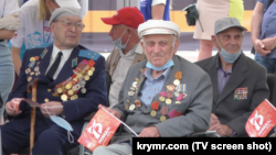 Участник Второй мировой войны, крымский партизан Куддус Юнусов (в центре) наблюдает за военным парадом. Симферополь, 24 июня 2020 года
