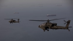 A handout photo released by US Central Command on April 18 shows AH-64 Apaches flying above the Strait of Hormuz during a patrol on April 17.