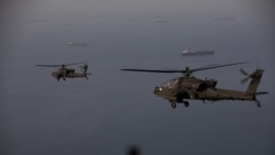 A handout photo released by US Central Command on April 18 shows AH-64 Apaches flying above the Strait of Hormuz during a patrol on April 17.