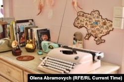 Мапа України та книги, перша з яких про чоловіка Катерини, ресторатора та військового Дениса Галушка, кафе Katy Cake, Намюр, Бельгія, 6 березня 2026 року