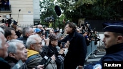 საფრანგეთის ყოფილი პრეზიდენტის, ნიკოლა სარკოზის ვაჟი ჟანი ესალმება მამის სახლთან შეკრებილ მხარდამჭერებს. პარიზი, 2025 წლის 21 ოქტომბერი