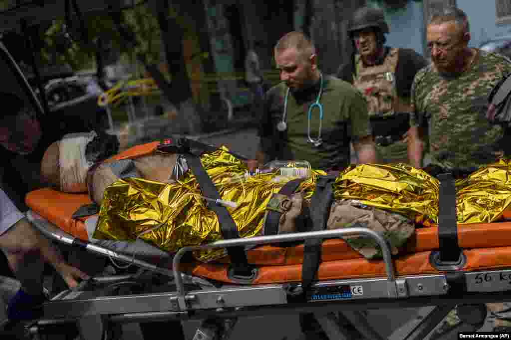Украинские военные смотрят, как раненого сослуживца увозят в госпиталь&nbsp;