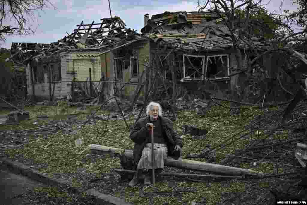 Egy idős nő ül az orosz rakétatámadások után rommá dőlt házak előtt&nbsp;Druzskivkában&nbsp;június 5-én