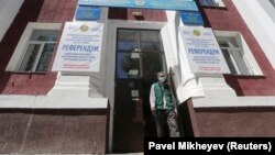 A man walks out of a building near posters informing of the upcoming referendum in Almaty, Kazakhstan, on June 1. 