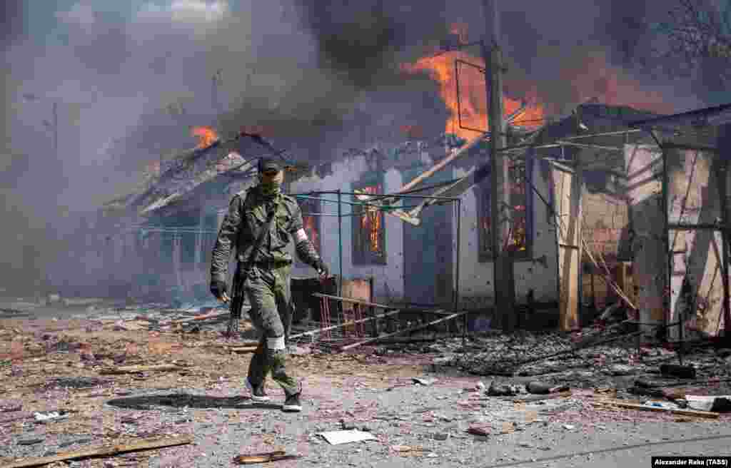 A pro-Russian fighter walks through a destroyed residential street in the eastern town of Popasna on May 8.&nbsp;