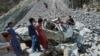 Onlookers gather at the wreckage of a fatal bus crash in Pakistan's Balochistan Province on June 8. 