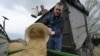 Farmers load oats into the seeding machine to sow in a field east of Kyiv.