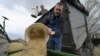 Farmers load oats into the seeding machine to sow in a field east of Kyiv.