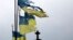 Damaged Ukrainian national flags flutter in the wind at a cemetery in Chernihiv in April.