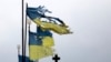 Flamuj të dëmtuar ukrainas të vendosura pranë një varreze në Çernihiv. Prill, 2022.