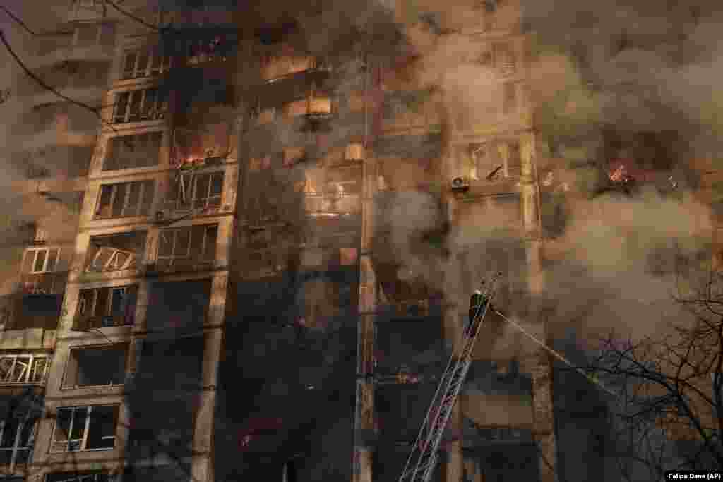 Ukrainian firefighters work at a bombed apartment building in Kyiv on March 15.