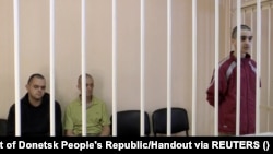 Britons Aiden Aslin and Shaun Pinner and Moroccan Saaudun Brahim, who were captured by Russian forces in Ukraine, sit in a courtroom cage in Donetsk on June 8.