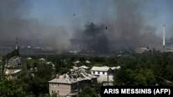 O clădirebombardată la Lisiceansk, localitate în apropiere de Severodonețk, de unde se vede ridicându-se un nor negru de fum și de praf, 9 iunie 2022.