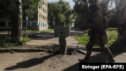 A Ukrainian soldier walks past part of a rocket near the front-line in the city of Syevyerodonetsk on June 2. 