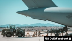 Un obuzier M777 american destinat Ucrainei, încărcat într-un avion de transport militar la baza aeriană March, California, 8 iunie 2022