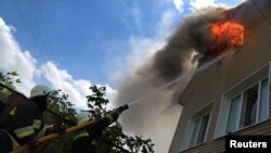 Рятувальники гасять пожежу в будинку в Харкові після російського обстрілу, 7 червня 2022 року