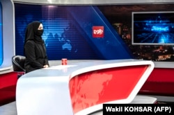 A female presenter for Afghanistan's Tolo News covers her face on May 22. Tolo News has dropped in popularity in Tajikistan since the Taliban took over.